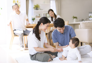 赤ちゃんをあやす両親と祖父母