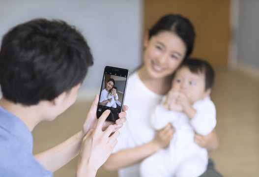 スマホで撮影される母親と赤ちゃん