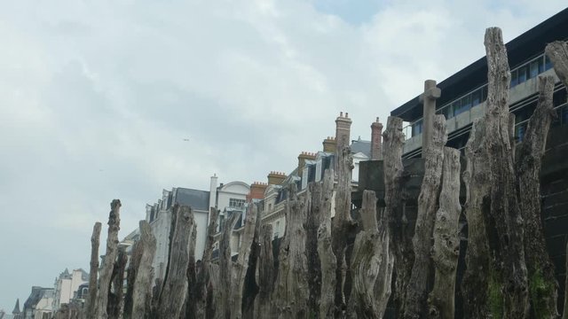 View of the old wooden breakwaters on the beach of the Atlantic Ocean  against the background of the houses and sky, Saint- Malo, France