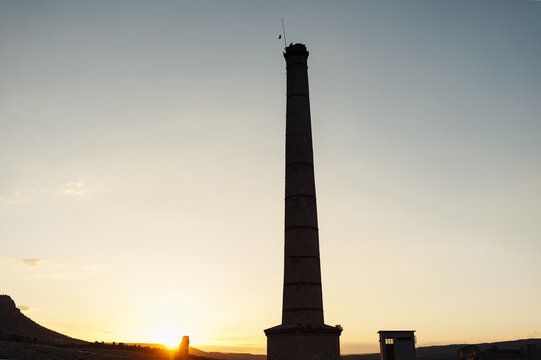 Birds flying over old chimney in an abandoned coal mine, Teruel, spain
