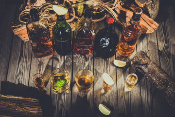 A lot of alcohol, whiskey, tequila, bourbon, brandy, rum on a wooden bar counter, vintage photo