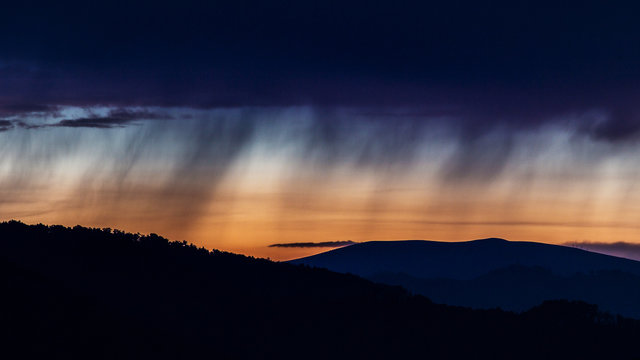 Fototapeta smooth rain water on sky and cloudy storm at sunset time over the layer of mountain in national park