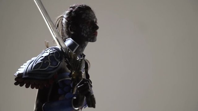A woman cosplayed a dark warrior from an anime, looking for someone on either side
