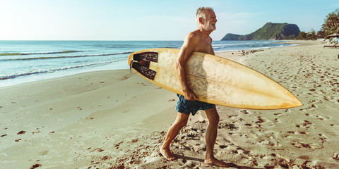 A man with a surfboard by the coast