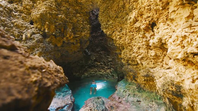 Boy floating in underground natural pool, Curacao