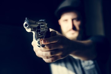 Man holding a gun with black background