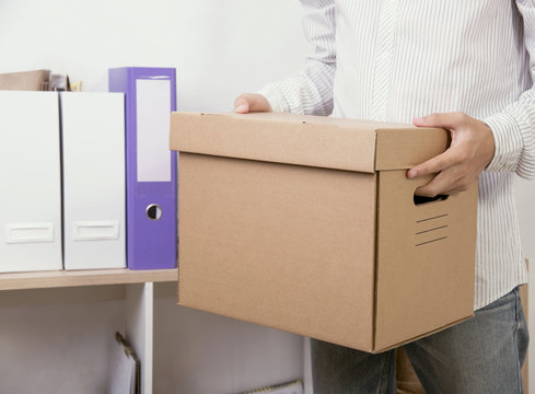 businessman holding personal items box ready moving leaving company. concept layoffs.