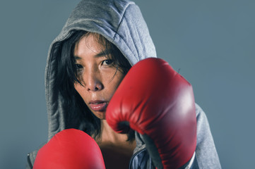 young fit and healthy Asian Korean boxer woman in fitness top hoodie and boxing gloves posing cool...