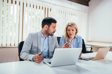 Obraz premium Two business people working in bright coworking office.