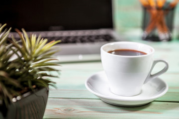 Digital tablet and cup of coffee on old wooden desk. Simple workspace or coffee break in morning. selective focus