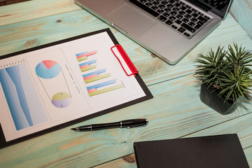Business Desktop. Photo diagrams graphs and numerals in the table on the paper
