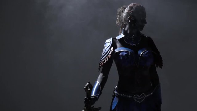 Dark warrior woman with white eyes posing with big sword