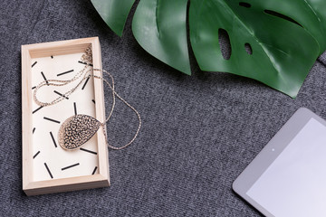 Female fashion concept. Simple design of  accessory and pad on dark color textile background.