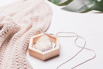 Female fashion concept. Simple design of beige color knitwear cloth for casual, with accessory on white background.