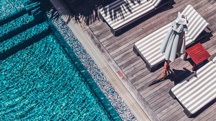 Umbrella and chair around luxury outdoor swimming pool