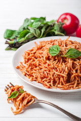 Italian spaghetti with a bolognese tomato meat sauce and basil in a plate. Copy space. Italian food concept.
