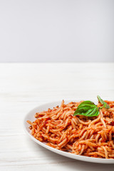 Italian spaghetti with a bolognese tomato meat sauce and basil in a plate. Copy space. Italian food concept.