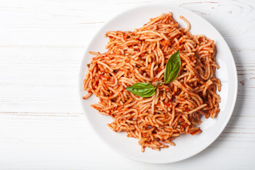 Italian spaghetti with a bolognese tomato meat sauce and basil in a plate. Copy space. Italian food concept.