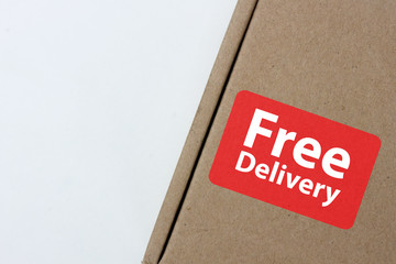 free delivery, business,online shopping, ecommerce and delivery service concept - brown box with note " free delivery " on a gray background.