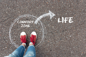 Exit from the comfort zone concept. Feet  standing inside circle comfort zone and outward arrow chalky on the asphalt. - obrazy, fototapety, plakaty