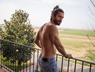 Young man with long hair being in a terrace