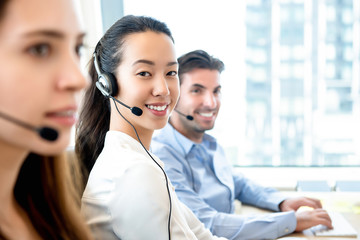 Smiling beautiful Asian woman working in call center