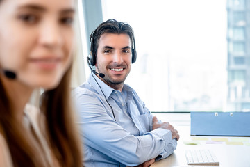 Smiling friendly Hispanic man working in call center