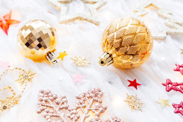 Christmas and New Year holiday background with decorations and light bulbs. Golden shining balls, snowflakes and star confetti.