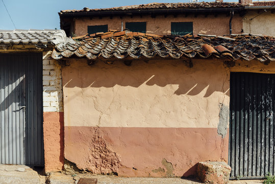 Clay roof tiles shadow over orange wall in a rural house
