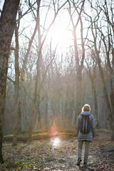 The girl in the grey jacket and with a rucksack on his back walks in the morning in the autumn...