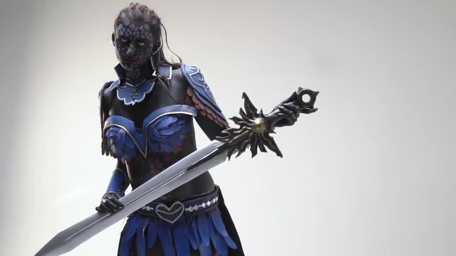 A drow woman with white eyes posing with a sword, slow motion