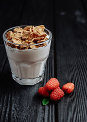 homemade yoghurt with flakes and raspberries on  dark wooden background
