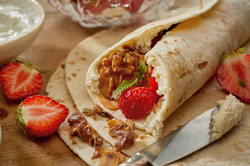 Making strawberry, walnut and cream wraps