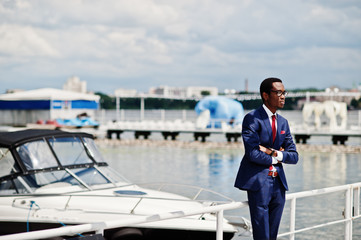 African american happy successful man at suit against yacht. Rich black business man.