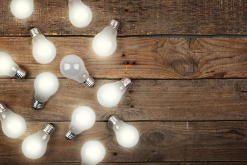 Vintage bulbs on wooden background - idea, innovation, teamwork and leadership concept. Space for text