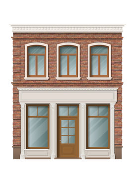 Old brick building facade with windows and shop on ground floor. Traditional classic architecture of front building. Storefront with large windows on the ground floor.