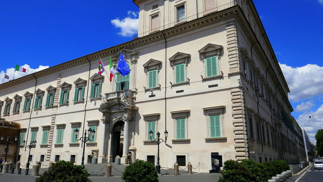 Palast des Präsidenten von Italien in Rom mit Eingang und Flaggen vor strahlendblauem Himmel