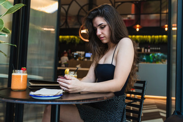 Young lady browsing smartphone in cafe