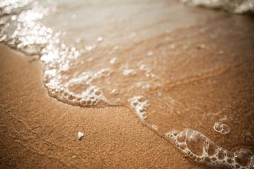 Soft wave of the blue sea on a sandy beach.