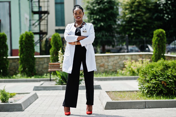 African american doctor female at lab coat with stethoscope outdoor.