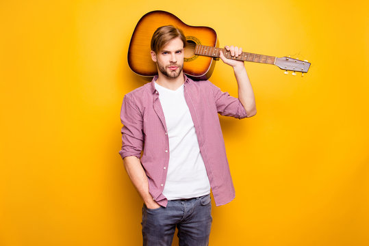 Portrait of handsome confident attractive serious proud focused romantic stylish cool swag guitarist carrying acoustic guitar on shoulder isolated background copy-space