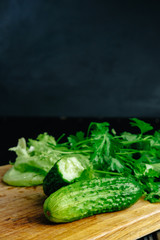 fresh hommade cucumber on the board with salad parsley dill celery