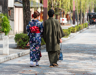 Couple in a kimono on a city street, Kyoto, Japan. Back view.