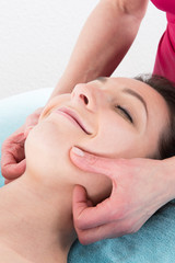 Obraz na płótnie Canvas young woman lying receives a facial massage