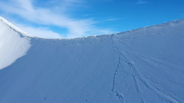 Stunning aerial drone footage flying up to a mountain ridge (arete) near the summit of Aletschhorn mountain in the Bernese Alps, Switzerland. Ebnefluh and Gletscherhorn mountains in the background.