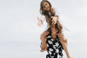 Mother and daughter holding hands and walking on beach. Mom and dauther happy family lifestyle concept