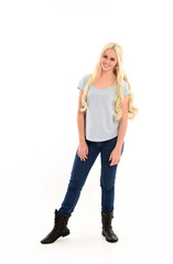 full length portrait of blonde girl wearing blue shirt and jeans, standing pose isolated on white studio background.