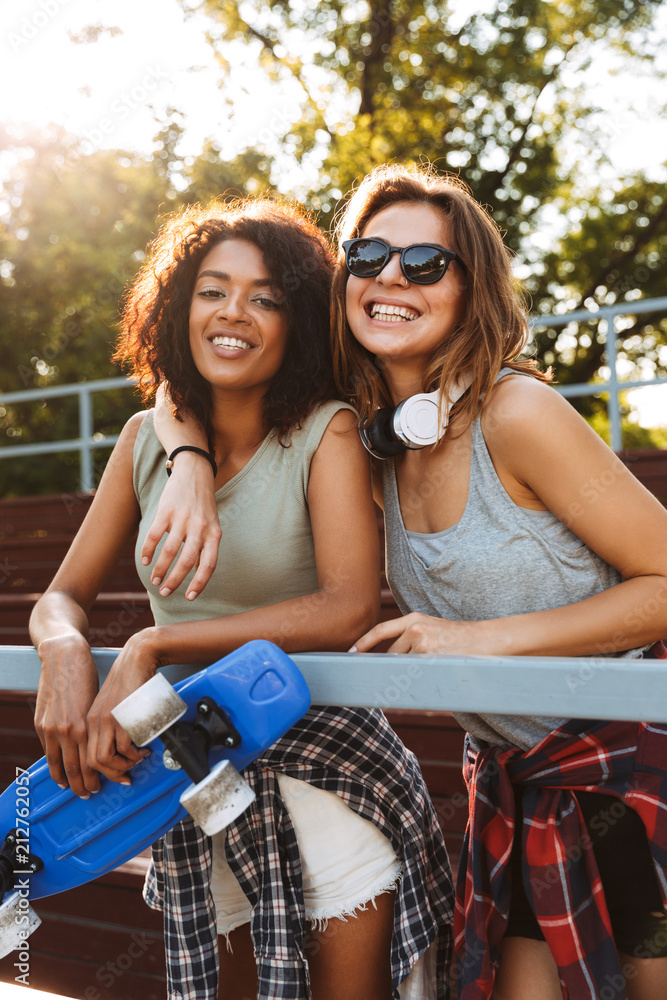 Canvas Prints Two joyful young girls with skateboard