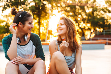 Two happy young girls having fun while sitting and talking