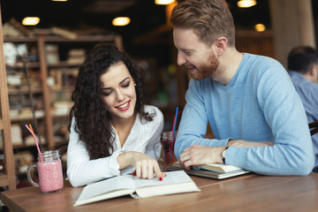 Young students spending time in coffee shop reading books